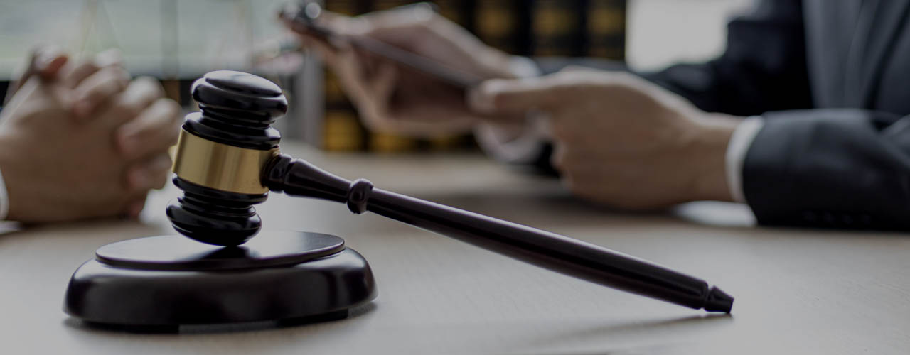 A small court judge’s hammer is placed on the lawyer’s table, th