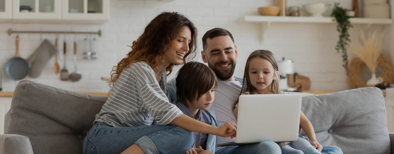 Happy Family With Kids Sit On Couch Using Laptop