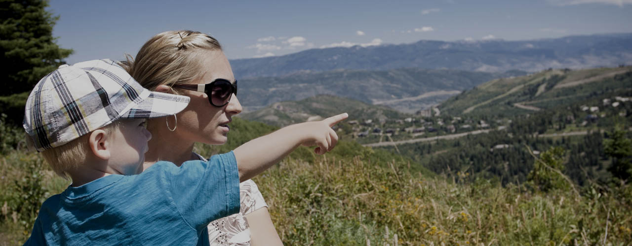 Child pointing while on a family hike in the mountains